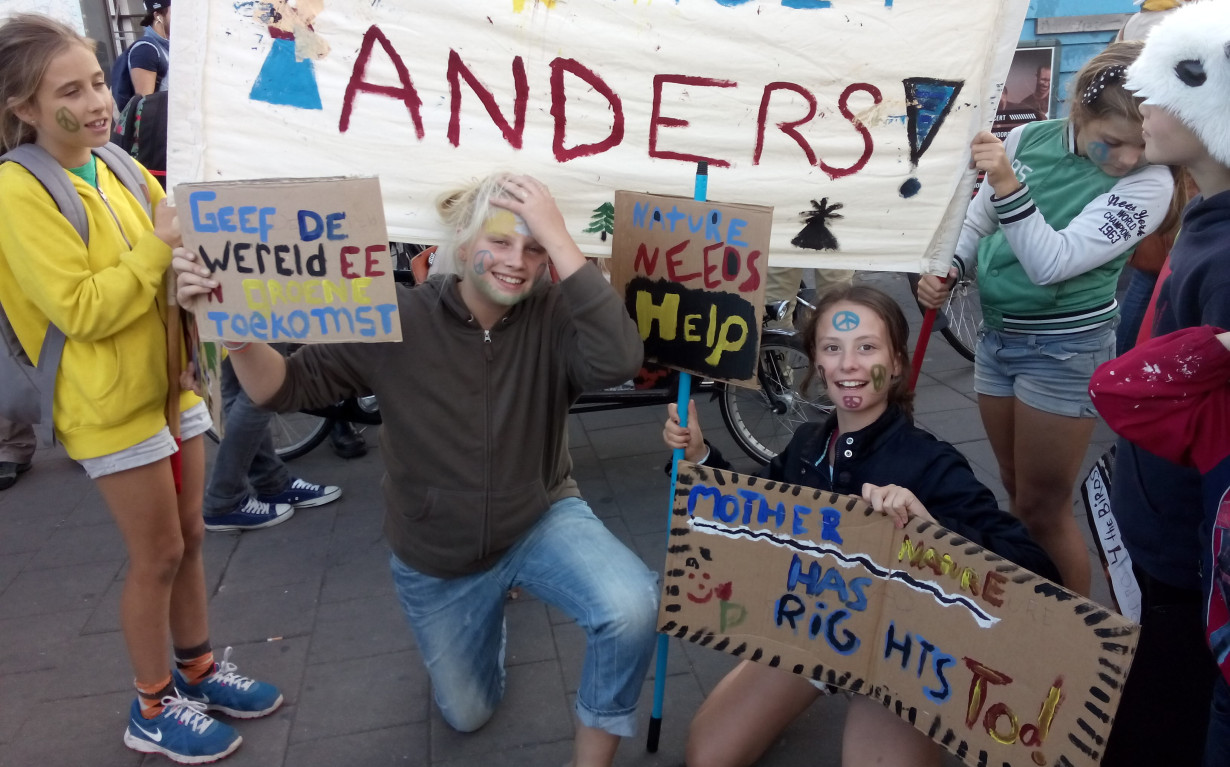 Kinderen staan met protestbordjes waarop onder andere staat De Aarde Heeft Rechten