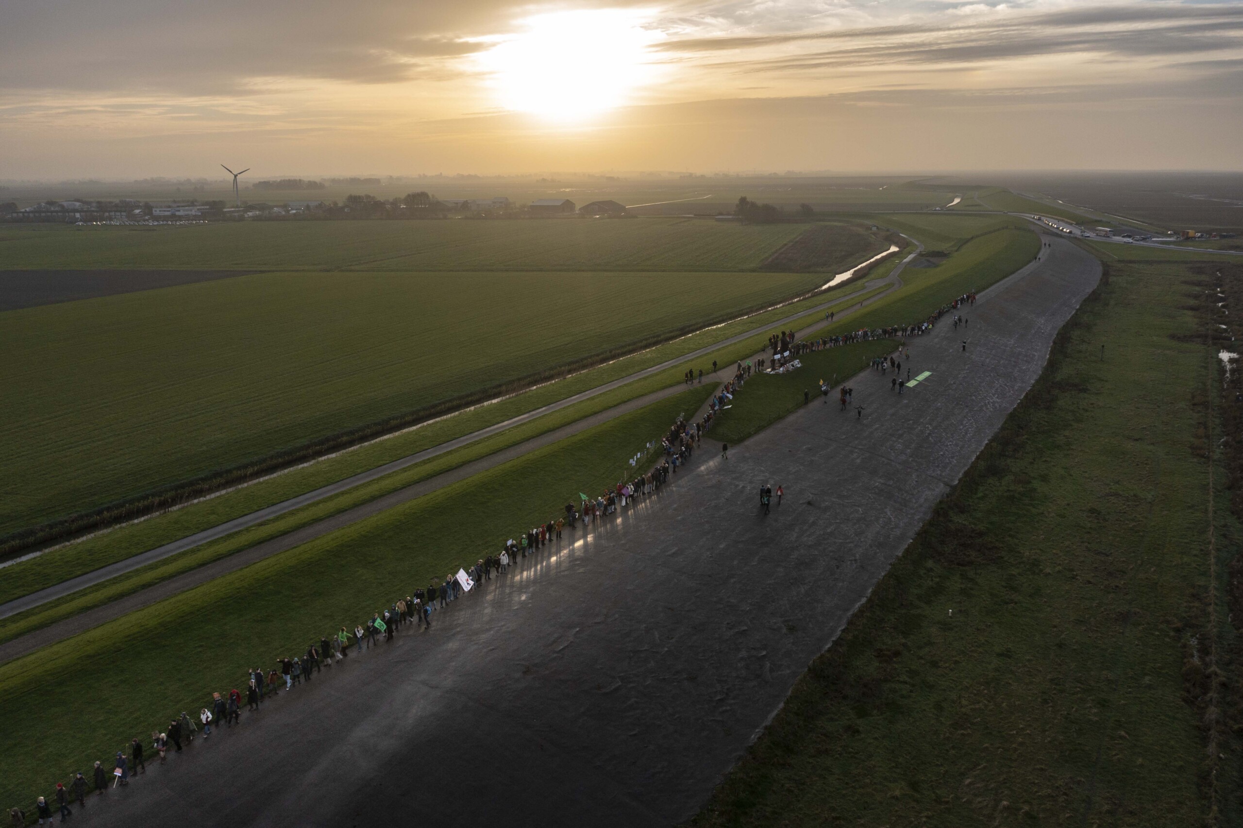 Demonstratie tegen gasboringen in het waddengebied. Honderden demonstranten vormen een lint van mensen op de zeedijk bij Holwerd, Friesland. Foto: Merlijn Torensma